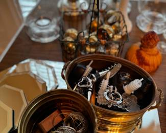 Wine stoppers and napkin ring sets in brass containers