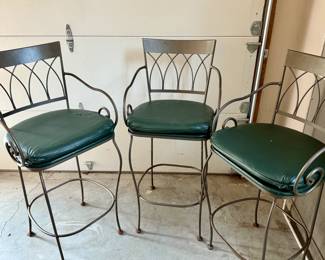 Metal bar stools with green leather seats