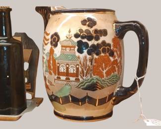 The pitcher features the "Gaudy Willow" pattern, which is a colorful variation of the classic Blue Willow Asian motif, enhanced with colors like brown, blue, and gilt accents. 
Manufacturer:
It was produced by Buffalo Pottery. 
Time Period:
The Gaudy Willow pattern was introduced in 1905, and early pieces like this pitcher can be dated to around that time. 