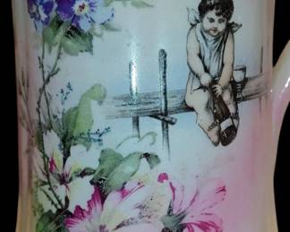 French pitcher Sevres France
Hand Painted floral Angel sits on a fence with a goblet/ opening a bottle of wine/champagne