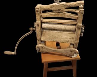 Primitive wooden ringer washer designed to clamp to the side of a wash tub. Hand crank for ringing the water out of the clothes. Made of cast iron and wood