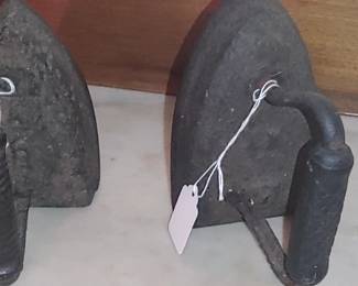 antique cast iron "sad iron" or "flat iron," used historically for pressing clothes
Repurposed as door stops these days
