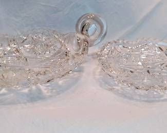 American Brilliant Cut Glass Handled Nappy Bowl Candy Dish
Here's a little history on the Nappy dish
Crystal dishes were called "nappy" dishes because the word "nappy" in antique glassware refers to a small, shallow, open serving bowl, often with a handle. The term derives from the obsolete Middle English word "nap" or "knapf," meaning a rimless bowl or drinking cup. Originally a simple bowl, the term evolved to describe a small dish used for serving berries, nuts, or candies, a use that continues today for such dishes.