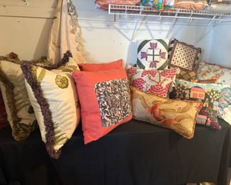 a lot of custom designer pillows