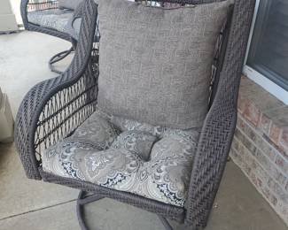 Pair of swivel wicker rocking chairs with side table.