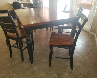 Bar height table [6] sturdy chairs. The leaf hides within the table base.