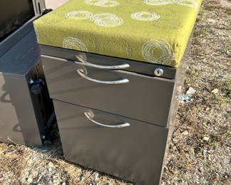 3 drawer mobile pedestal file cabinet with cushion on top.