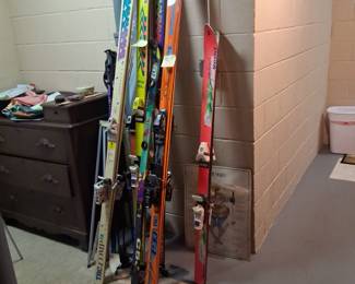 Lots of skis in good condition with poles and other ski paraphernalia available