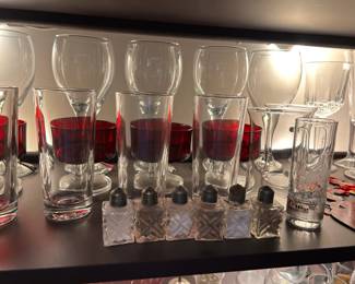 Salt and pepper shakers, red parfait dishes, and assorted glasses