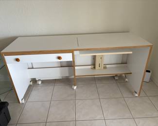 Horn Sewing Cabinet with manual hydraulic lift and on wheels. Measures 60” X 19 1/2”   Has back extension that fold up. With fold up extension 60” X 39”