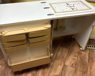 Sewing cabinet with manual hydraulic lift on wheels. Closed it measures 20” X 24”.  Open it measures 20” X 48”.
