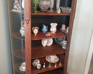 Oak china cabinet filled with collectibles