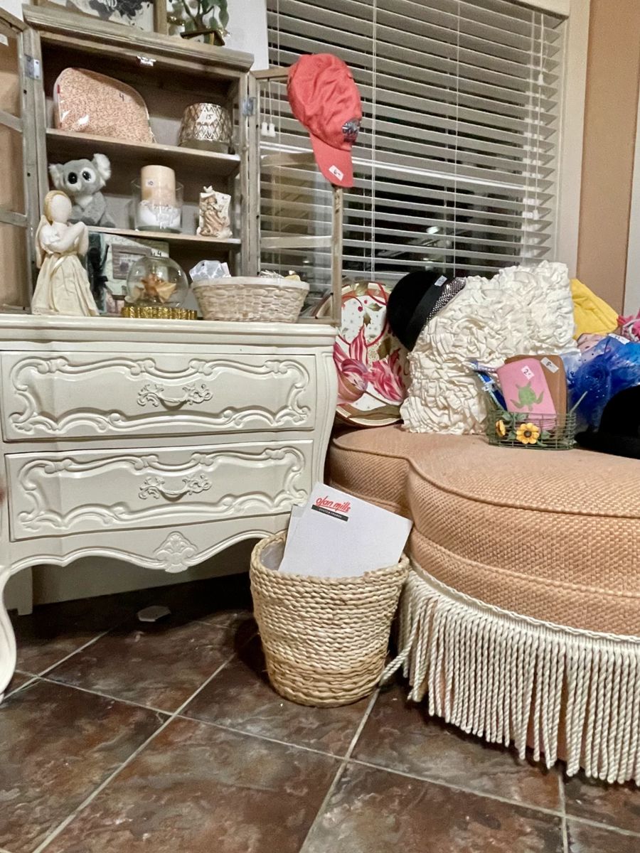 white nightstand, peach ottoman, boho waste basket, pillows, hats, hatbox 