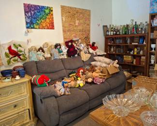 Recliner couch, collectibles dolls candy dishes and large dresser on left