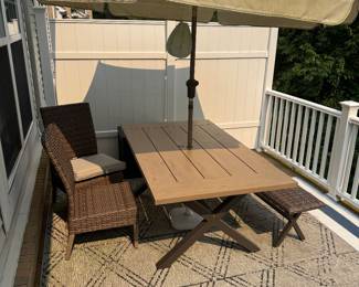 Out door metal (wood tone look) table with bench and 2 armless chairs/ umbrella/rugs