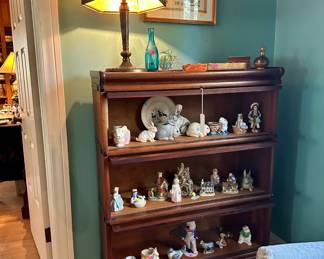 Stacking bookcase $450, bent panel lamp $325, framed needlework sampler $25, misc porcelain figures most $5-10
