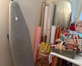 Ribbon, bolts of fabric and wall paper and vintage ironing board