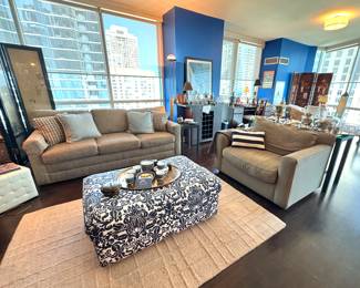Modern High-Rise Living Room with City Views, Blue Accent Walls, and Cozy Neutral Sofas