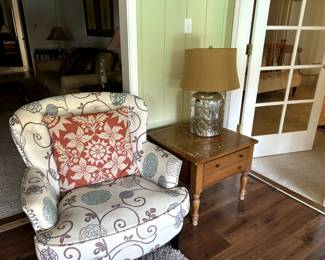 Upholstered chair with side table and lamp