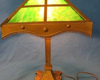 Lot 451. Slag glass lamp with a metal base. One glass panel is missing. No manufacturer's mark.