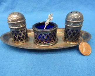 Lot 464. Silverplate condiment set. Cobalt blue glass salt, pepper, and mustard container. Includes original spoon.