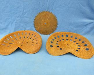 Lot 410. Two old farm implement seats and a saw blade