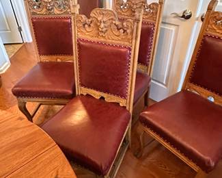 (3) Set of 6 high-back oak dining room chairs and one matching arm chair. Chairs have Lion or Northwind Face in center, leaf ears, claw feet, upholstered back and seat. Chairs 42-12/"h, armchair 45"h. Chairs $4,200