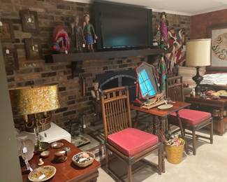 View of fireplace end of red room with chairs, art, pottery, tables