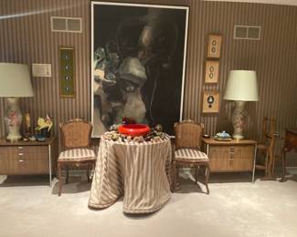 Large Alexander Nepote painting dominates wall, mid-century chrome trimmed tables, pair of cane back chairs