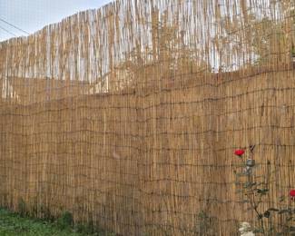 Reed Fence shown with a fabric fence running the lower length behind. Fence will be rolled up for sale.