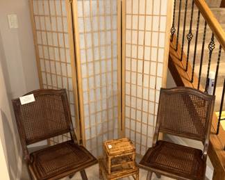 Room dividing screen and cane back folding chairs.