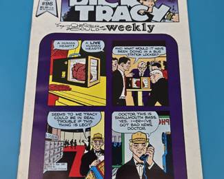 Dick Tracy Weekly comic book, specifically issue #96.
The cover features a four-panel comic strip depicting a scene where a human heart is discovered in a bus station locker, leading to a call to a character named "Smallmouth Bass" who delivers "bad news" to a doctor.