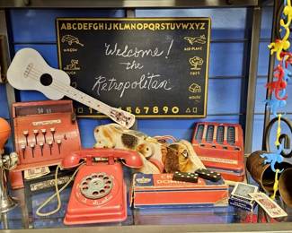 10- Items in this Vintage Toy Display: Bike Horn, Pressed Steel Cash Register w/ Cash, Telephone, & Adding Machine
Barrel of Monkeys, Learning Chalkboard Sign, Dominoes, Playing Cards, Carnival Toy Ukelele, Fisher Price Pull-Along Snoopy Toy
