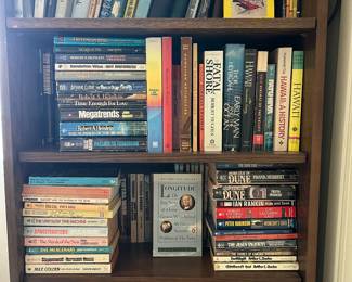 Several book cases filled with paperbacks and hard covered books!