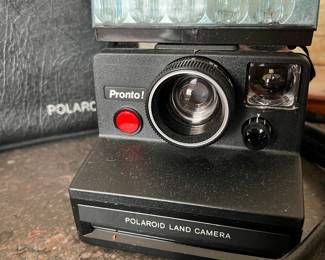 POLAROID LAND CAMERA -- "PRONTO." SIMILAR TO THE POLAROID "SWINGER" AND OTHE INSTAMATIC CAMERAS, THEY ARE GETTING HARDER TO FIND AND ARE BECOMING MUCH MORE COLLECTIBLE. WE ALSO HAVE NEW/OLD BOXED 600 FILM.