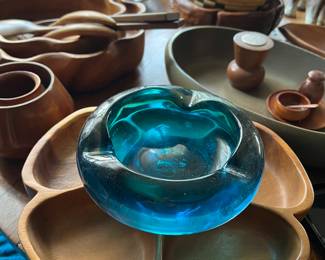 Under the blue glass ashtray are several monkey-pod wood "pupu trays," (appetizer bowls) -- salt & pepper, misc. serving trays / bowls -- very Polynesia!