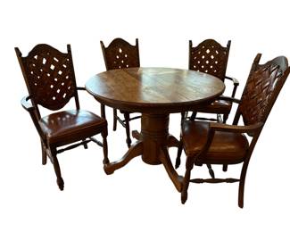 Dining room table with one leaf and four captain's chairs, the chairs have leather backs and leather seats