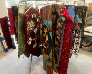 A whole rack of hand crafted quilts, wall hangings, table runners, and more!