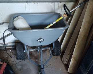 Fertilizer spreader towed behind a lawn tractor