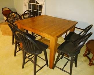 Square high top wood dining table with six black chairs