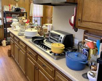 Prominently placed here are the ceramic pots, the toaster oven, and a cake stand. Yes, that is a cast iron skillet.