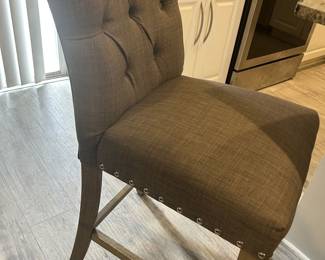 Three gray upholstered bar stools