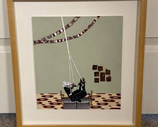Kelly Duffield Mixed Media Artwork
This mixed media collage painting features a scene depicting two children on a tire swing. One child wears a unicorn mask, while the other has curly hair and is dressed in black. The background features a light green wall with several brown-framed pictures. The floor has a cream color with a red pattern. The frame is made of light wood.