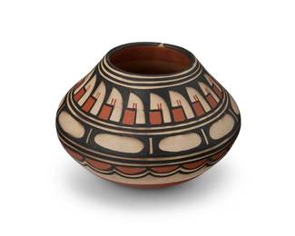 306
Robert Tenorio (b. 1950, Kewa/Santo Domingo Pueblo)
A polychrome pottery jar, late 20th/early 21st century
Incised to underside: [stars] Robert Tenorio / Santo Domingo Pueblo / NM
The three-color jar with orange and black banded feather and cloud motifs on a white slip ground
5.5" H x 8.375" Dia.
Estimate: $300 - $500