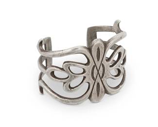 320
A Southwest sandcast sterling silver cuff bracelet
Early/mid-20th century
Unmarked
An openwork cast silver cuff with concho-style hooked floral motif
6.375" total inner C x 1.875" H, with a 1.125" gap
65.1 grams
Estimate: $400 - $600