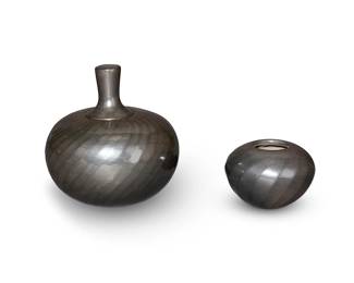 21
Denny Gutierrez (1942-2013, Santa Clara Pueblo)
Two Santa Clara blackware pottery items, late 20th century
Each inscribed to underside: Denny Gutierrez / Santa Clara Pueblo
Comprising a blackware melon jar with swirling ridges and a lid, and a small blackware melon jar
2 pieces
Larger overall: 4.5" H x 4.5" Dia.; Smaller: 2" H x 3" Dia.
Estimate: $500 - $700