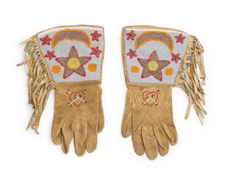 291
A pair of Plateau beaded hide gauntlet gloves
Mid-20th century; Northwest United States/Canada
The pair of beaded hide gloves with a beaded monogram "S P" pierced heart motif to top of hand and fringed gauntlet tops with star and crescent moon motifs, the gauntlets lined with printed cotton calico
2 pieces
Each: 14" L from tip to opening x 7" W at wrist approximately
Estimate: $200 - $400