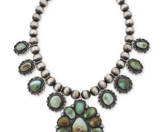 311
An Ernest Roy Begay Navajo silver and turquoise squash blossom necklace
Ernest Roy Begay (b. 1956, Diné)
Late 20th/21st century
Stamped: ERB / Sterling
A chunky sterling silver necklace with a large cluster-set turquoise pendant and eight graduated set turquoise "blossoms" all suspended from a single strand of large silver beads
21.75" L x 4" H
253.1 grams gross
Estimate: $600 - $800
