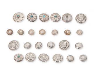 81
A group of Navajo silver concho buttons
Mid/late 20th century, Diné
Unmarked
Comprising multiple sterling silver stamped buttons in various sizes and styles, including two matching 6-piece sets of stamped buttons (1.5" Dia. & 1" Dia.), a set of 4 matching buttons with set turquoise (1.5" Dia.), two single buttons with set turquoise (1.5" Dia.), and a matching set of 7 stamped buttons
25 pieces approximately
105.4 grams gross
Estimate: $200 - $400
