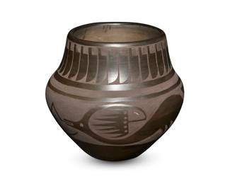 4
Maria & Julian Martinez (1887-1980 & 1879-1943, San Ildefonso Pueblo)
A blackware pottery jar, mid-20th century
With incised signature to base: Marie + Julian
The pottery olla with an Avanyu motif with a band of clouds and a band of feathers to rim
6.25" H x 7" Dia.
Estimate: $600 - $800
